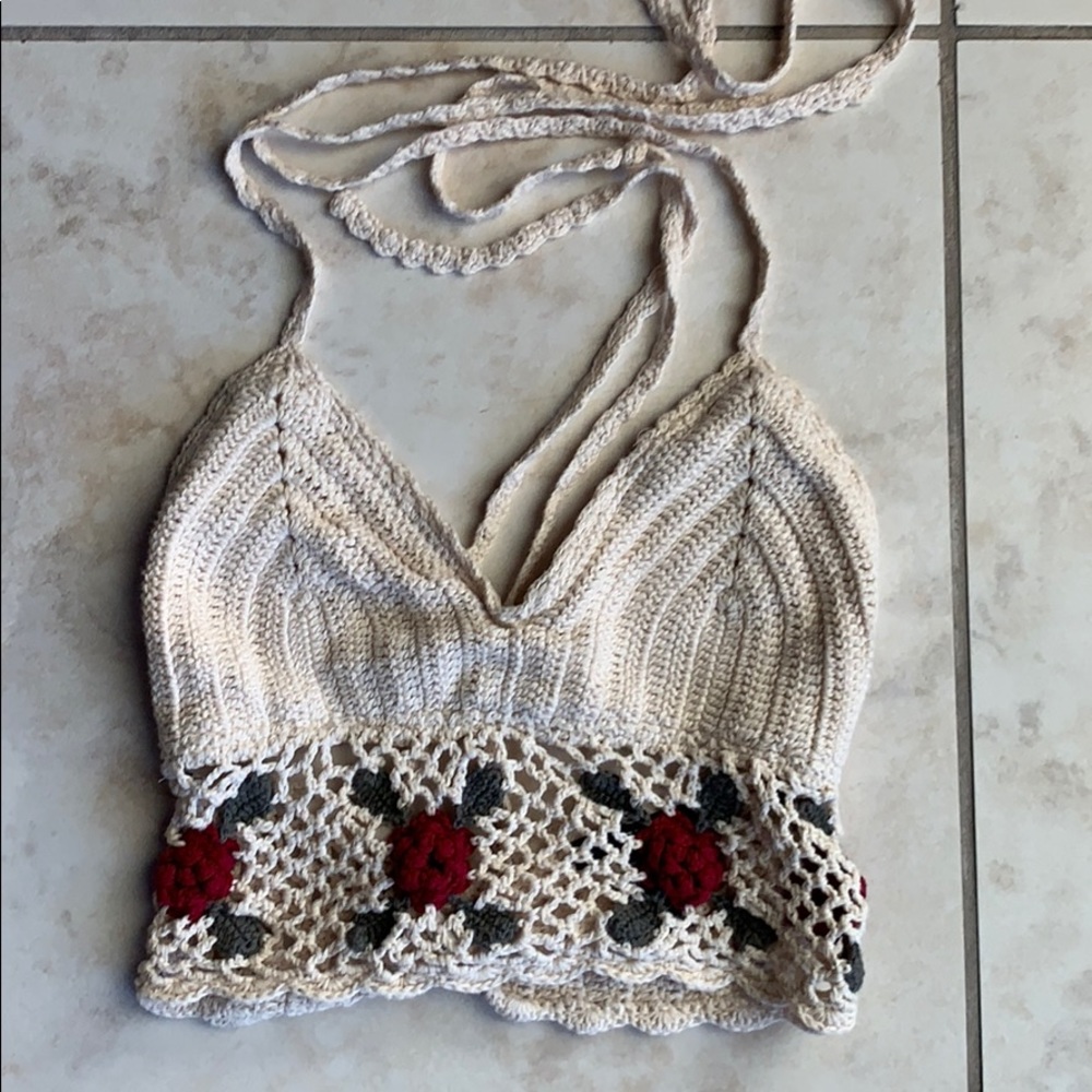 Beige knit crop top with floral design in front.